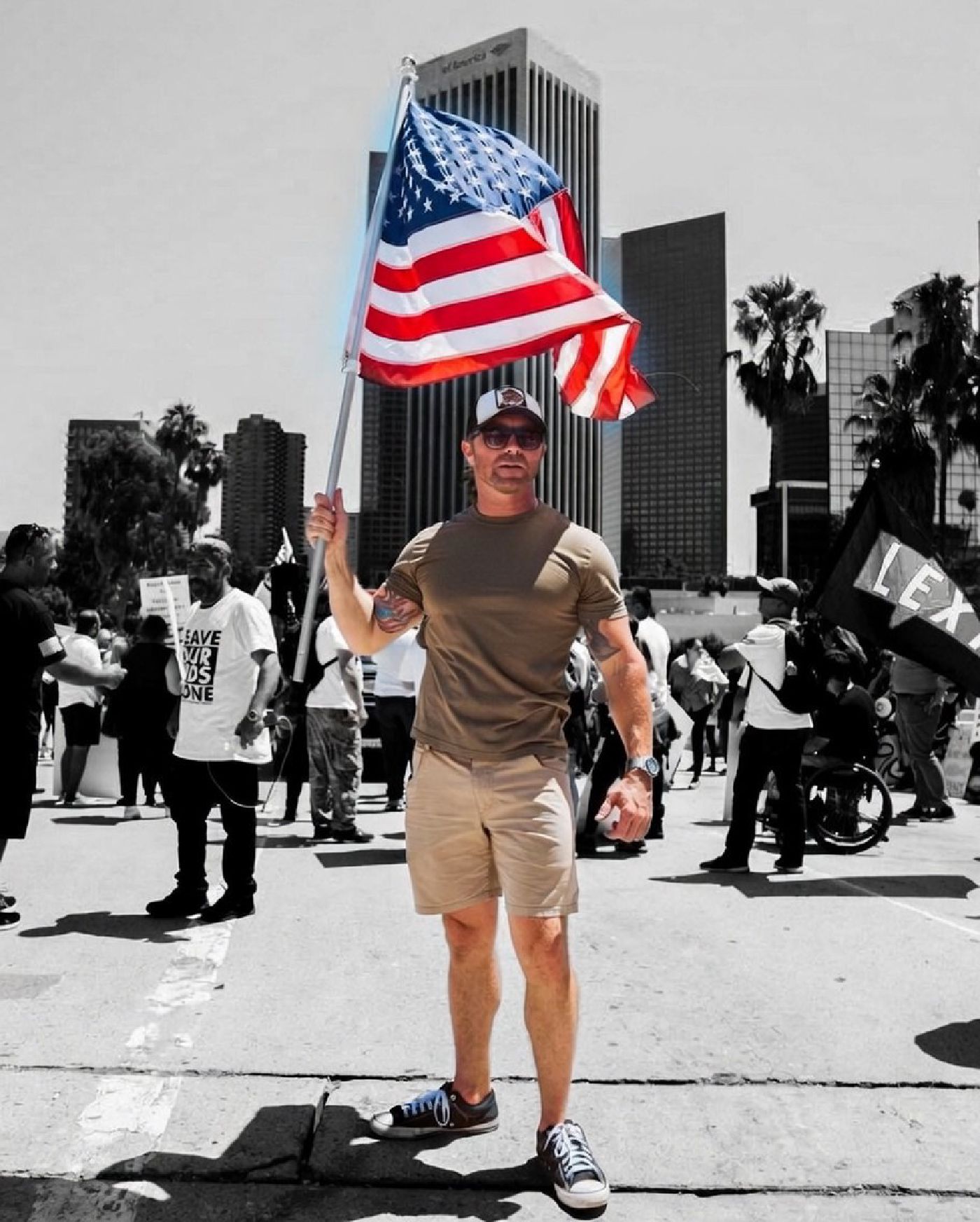 Bryce Henson carrying an American flag through a crowd at a rally